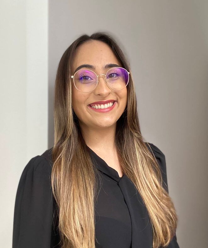 Dra. Maiara Araújo sorrindo, em ambiente do escritório